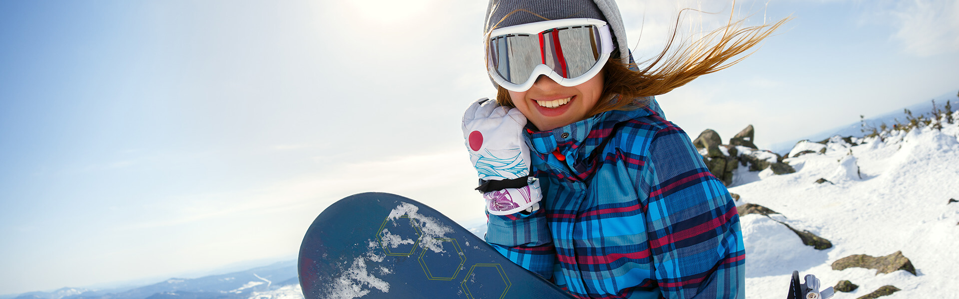 Female snowboarder smiling on the mountain